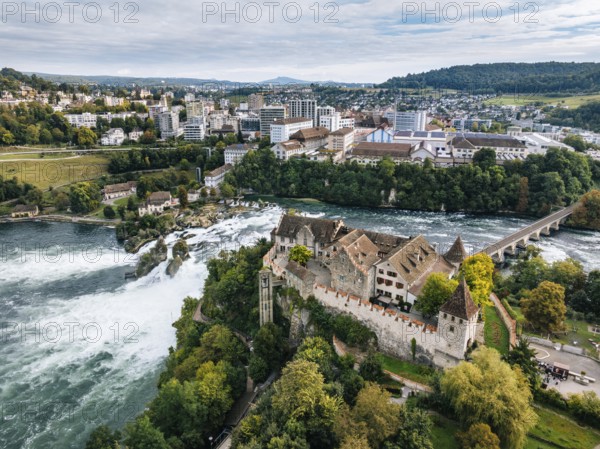 Aerial view of the Rhine Falls with Laufen Castle with autumnal vegetation, on the horizon the town