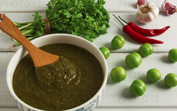 Tkemali sauce, traditional Georgian cuisine, green cherry plum, with ingredients for sauce,