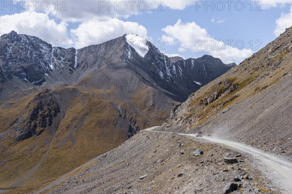 Narrow gravel track in mountain landscape at Chong Ashuu Pass, Tian Shan Mountains, Issyk-Kul,