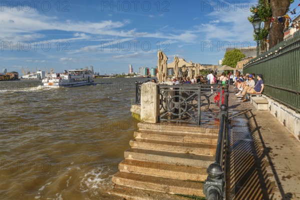 People enjoying the afternoon on the promenade at Travalgar Tavern, Greenwich, London, England,