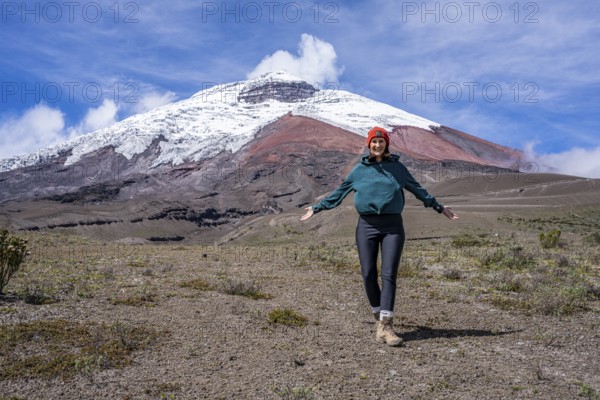 Women poses in front of the Cotopaxi volcano, Cotopaxi, Cotopaxi National Park, Latacunga, Ecuador,