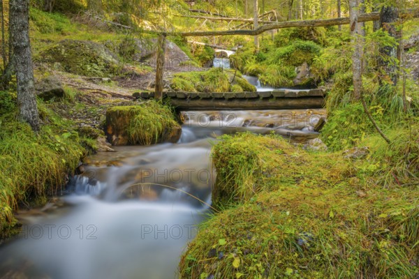 View of a wooden bridge leading over a torrent, long exposure, Dolomites, Puez-Geisler nature park