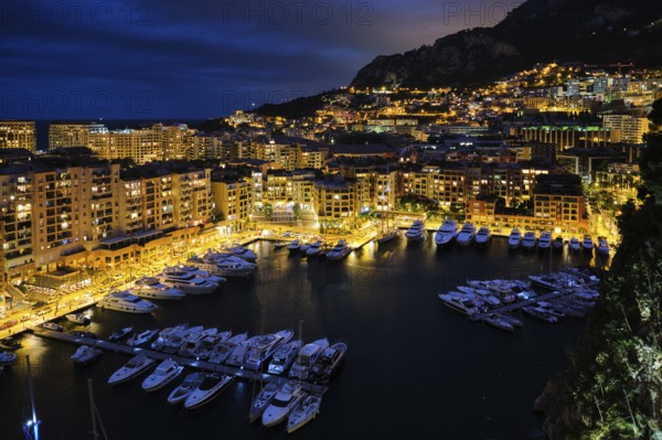 Aerial view of Monaco Monte Carlo harbour and illuminated city skyline in the evening blue hour