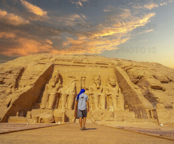 A young man walking towards the Abu Simbel Temple in southern Egypt in Nubia next to Lake Nasser.