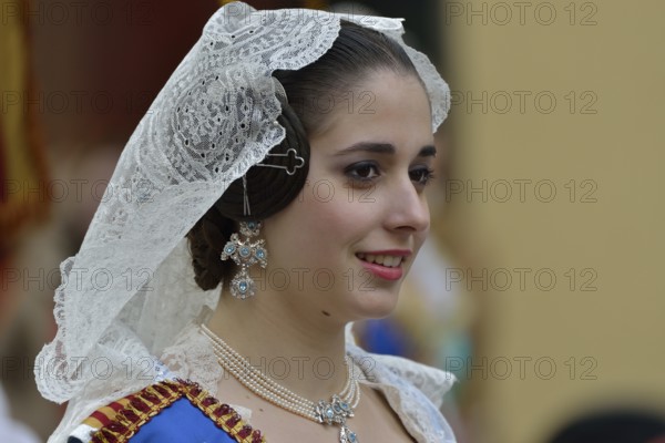 Fallas festival, woman in a traditional costume during the parade in the Plaza de la Virgen de los
