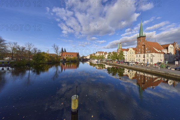 River Trave, quay wall, historic buildings, church towers of St. Marien and St. Petri, reflections