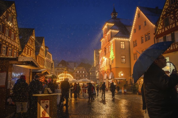 People with umbrellas strolling through the Christmas-lit old town market at night, Christmas