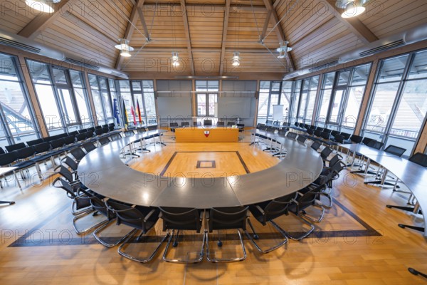 Large, modern conference room with wooden ceiling and large windows, equipped with table and