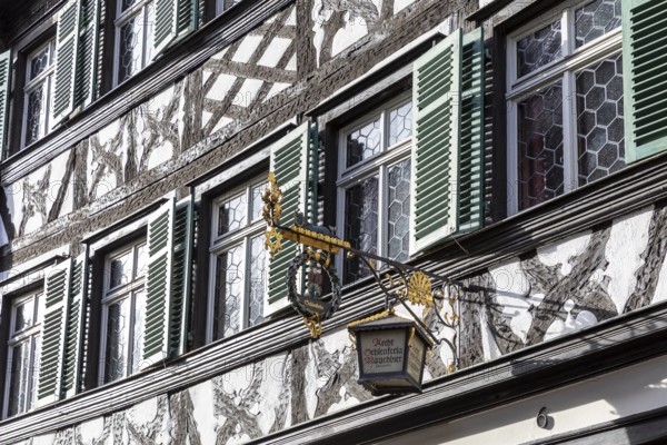 Façade with half-timbering and shutters and historic nose sign, famous Schlenkerla brewery,