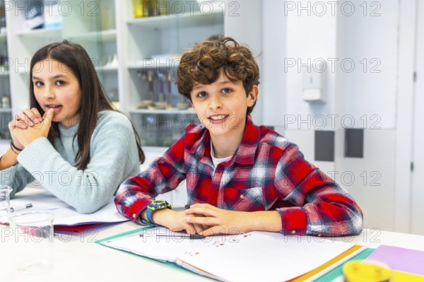 Smiling students sitting at desk in science classroom, learning and interacting during lesson,