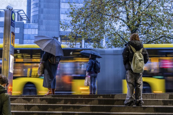 Autumn, rainy weather, bus stop at the central station, passengers waiting for the bus, Essen,