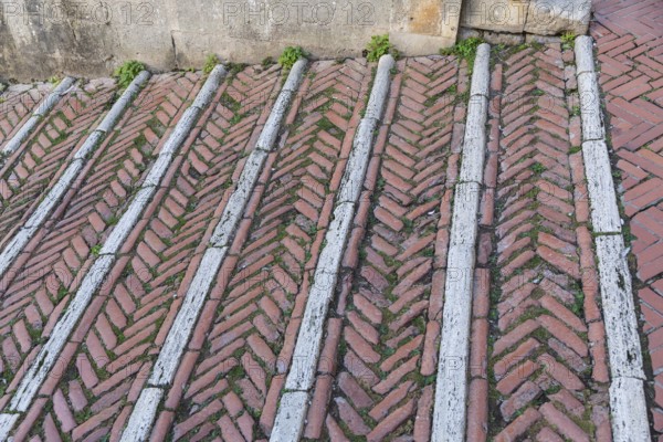 Brick-paved slope in the cathedral square in the medieval town of San Gimignano, province of Siena,