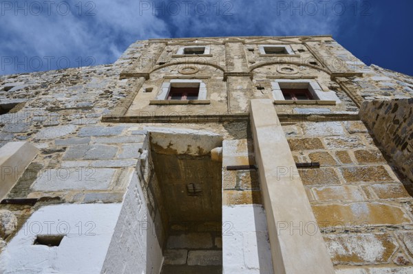 Old historic wall with windows and decorated stone in the sunlight, Querini Castle, Chora,