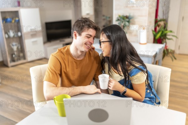 Young multi ethnic couple enjoying a quiet moment together at their home, sharing coffee and