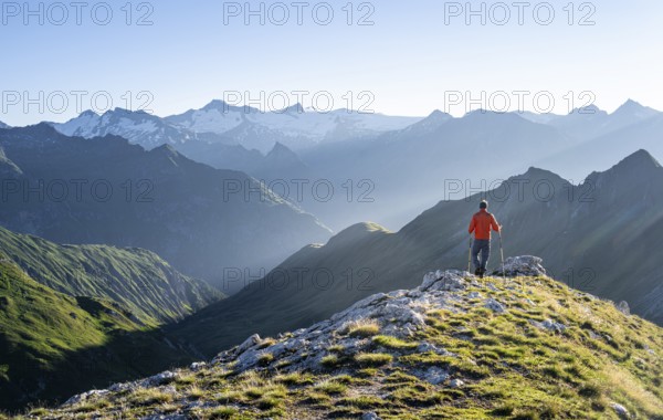 Hiker enjoying the mountain panorama in the morning, Venediger group, behind Dreiherrenkopf,