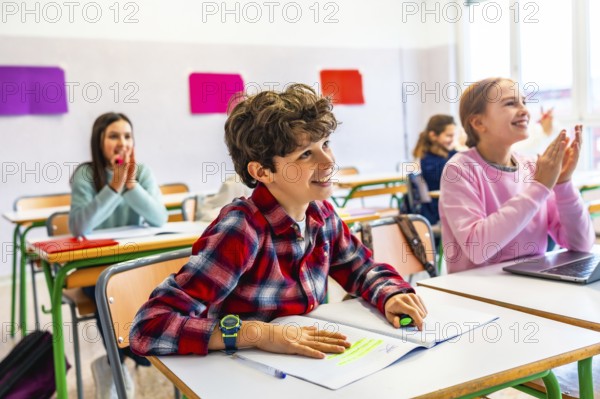 Elementary school students sitting at desks, attentively listening to the teacher while taking