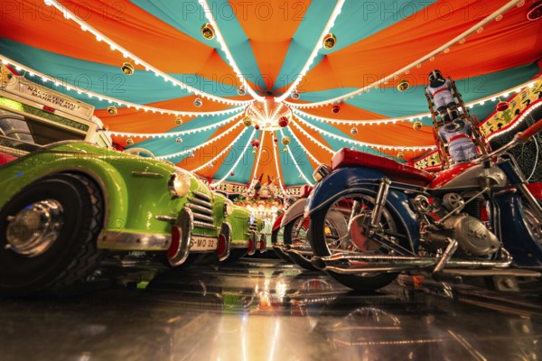 Carousel with reflective lights and colourful vehicles, Christmas market Ludwigsburg, Germany,