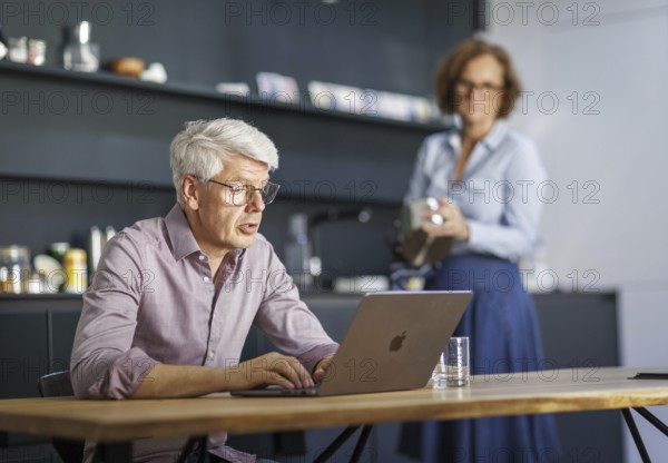 Symbolic photo on the subject of division of labour for couples in the household. A man sits in a