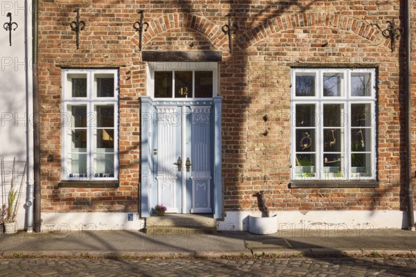 Historic brick house, entrance door, window, wall anchor, street An der Obertrave, Old Town,