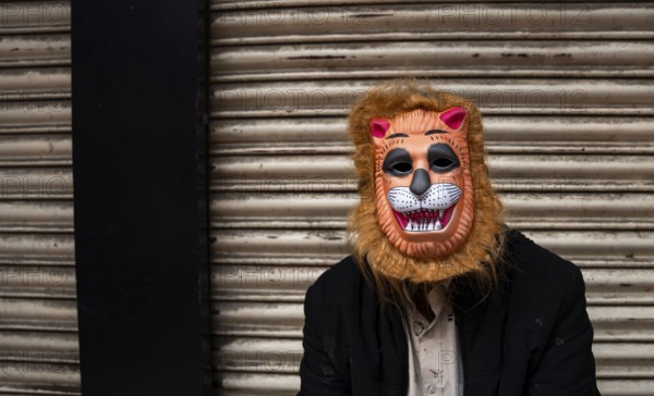 A person wears a mask to play Holi, the Hindu spring festival of colours, on March 14, 2025 in