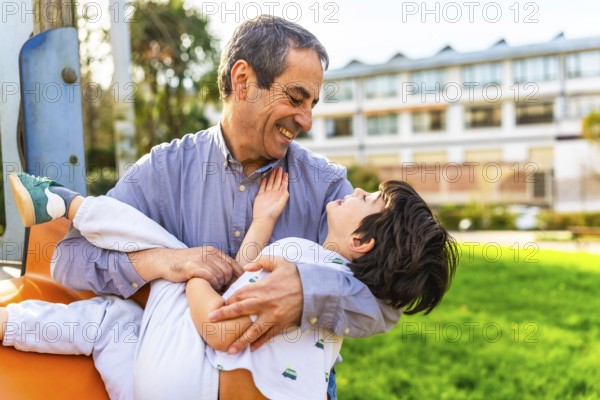 Grandfather and grandson enjoying playful moments together at the park, sharing laughter and