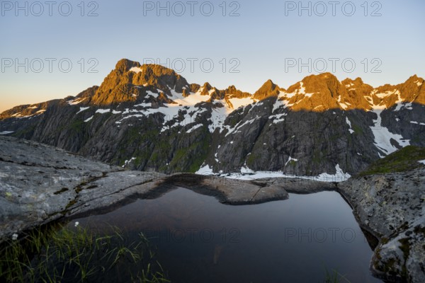 Rocky mountain peaks, small pond in moorland at Trollfjord Hytta, mountain landscape with alpenglow