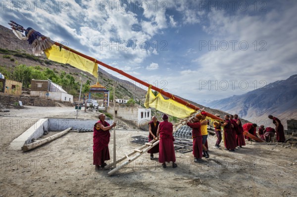 DHANKAR, INDIA, JULY 2, 2012: Tibetan Buddhist monks of Dhankar gompa setting up the pole with