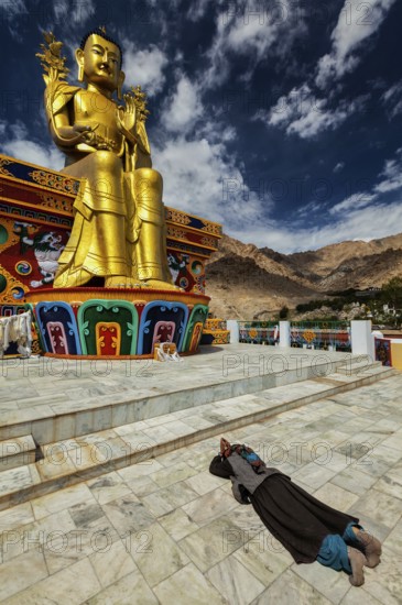 Tibetan Buddhist woman worshiping and praying Buddha Maitreya statue in Likir gompa (monastery),