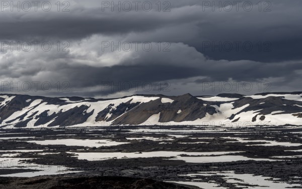 Snow-covered volcanic landscape with volcanic sand and petrified lava, crater of Askja volcano,