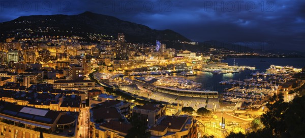 Aerial panorama of Monaco Monte Carlo harbour and illuminated city skyline in the evening blue hour