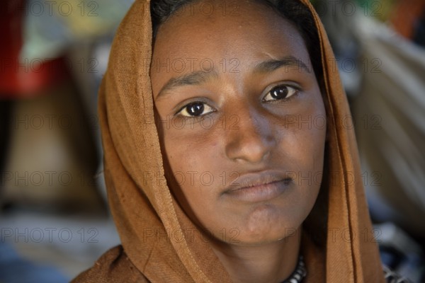 Young girl from a nomadic tribe, wearing headgear, portrait, Bayuda Desert, in Karima, Nubia,