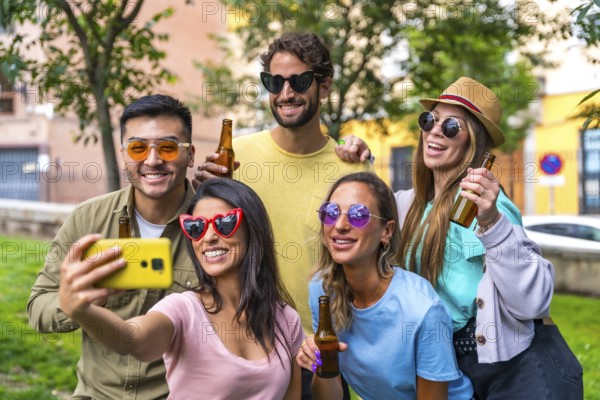 Multi ethnic group of friends partying in the city park taking a selfie, friendship and fun concept