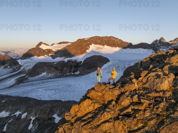 Atmospheric sunrise in a picturesque mountain landscape, alpenglow, aerial view, mountaineer on the