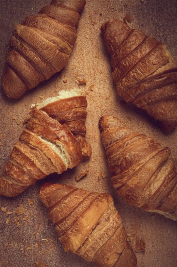 Fresh croissants, breakfast, top view, on the table, brown background, no people