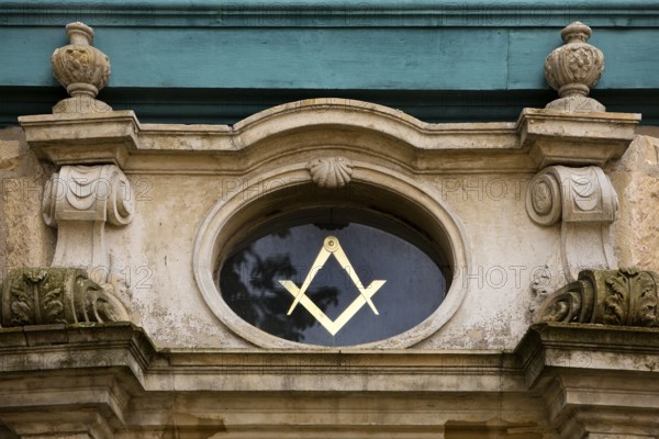 Close-up with compass and angle, two of the best-known symbols of Freemasonry on the lodge house,