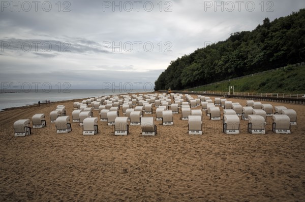 Rainy weather at the Baltic Sea, empty beach chairs, single walkers, view from above, long