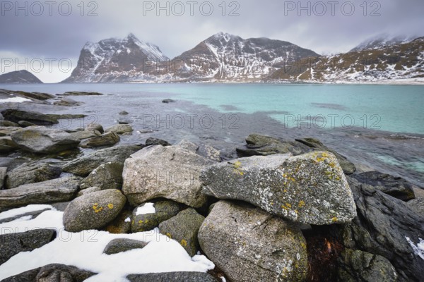 Rocky coast of fjord of Norwegian sea in winter with snow. Haukland beach, Lofoten islands, Norway,