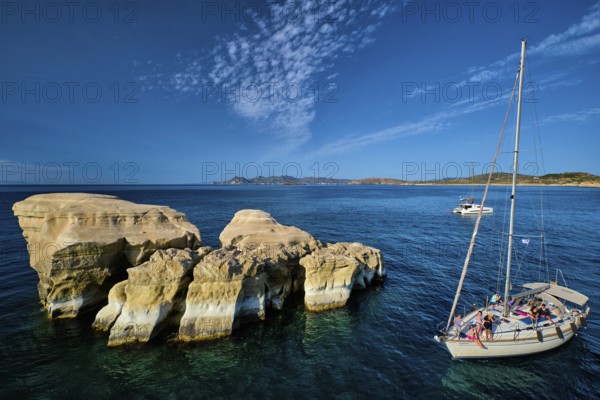 Sarakiniko, Greece, May 23, 2019: Yacht boat with tourists passing near white rocks of famous