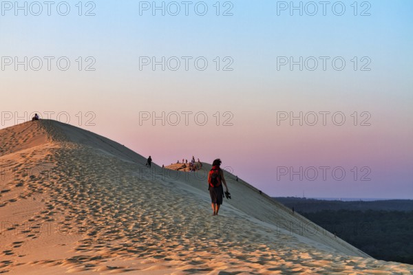 Hikers, tourists on hiking dune enjoying sunset, Dune du Pilat, dune near Arcachon, Gironde,