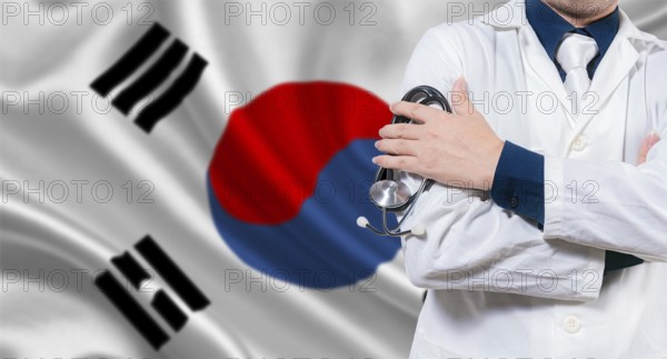Doctor with stethoscope on South Korean flag. Doctor with crossed arms on South Korean flag.