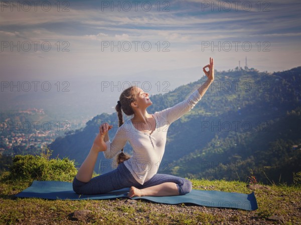 Yoga outdoors, young sporty fit woman doing stretching yoga asana Eka pada rajakapotasana,