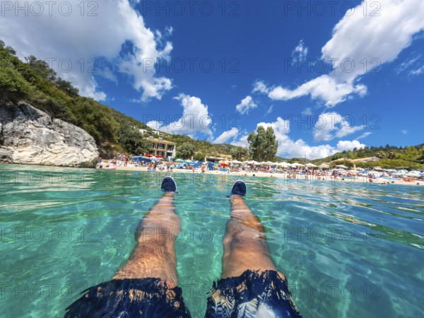 A man resting in the sea on the beach in summer of Paralia Mikros Gialos in the south of the island
