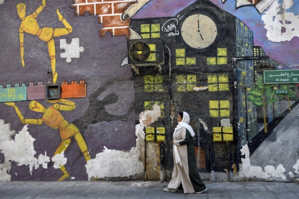 Veiled woman in front of mural, graffito, Al Khobar, ash-Sharqiyya province, Persian Gulf, Saudi