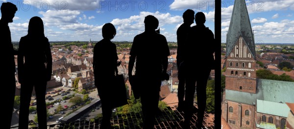 View of the old town from the historic water tower, visitors silhouetted in front, Lüneburg,