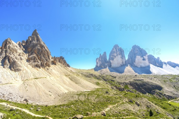 Panoramic view of the tre cime di lavaredo with hikers enjoying the sunny summer day in the italian