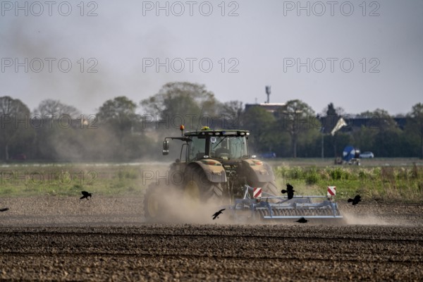 A tractor works a field, due to long dryness in spring, no rain for more than 4 weeks, the fields