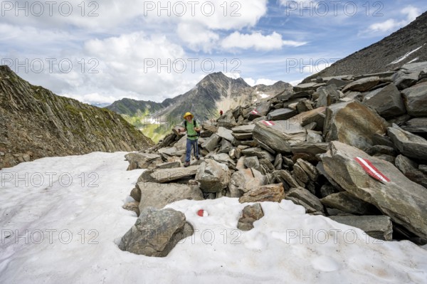 Mountaineer on a hiking trail in boulder terrain with snow, Lasörling Höhenweg, Lasörling Group,