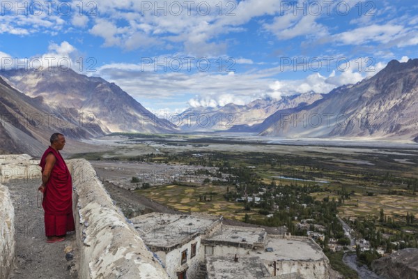 DISKIT, INDIA, SEPTEMBER 12, 2012: Unidentified Tibetan Buddhist monk praying on roof of Diskit