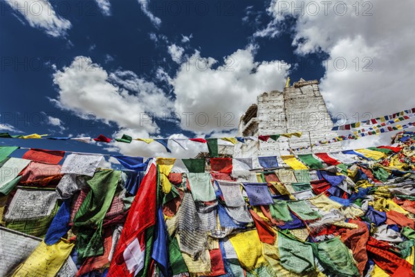 Ruins of Victory Fort Tsemo on the cliff of Namgyal hill and colorful Buddhist prayer flags with