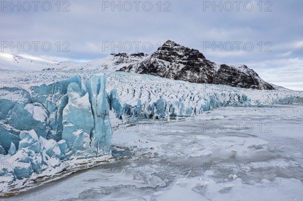 Glacier break-off and snow-covered icebergs in the Fjallsarlon glacier lagoon, with the